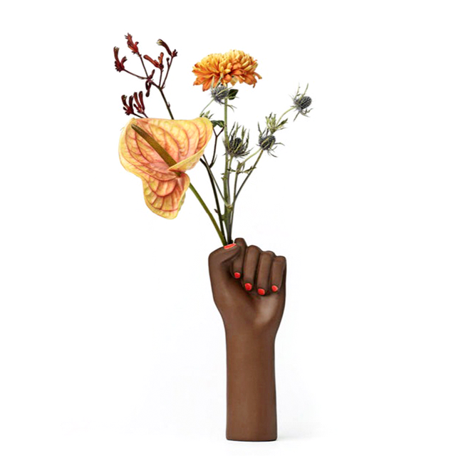 ceramic vase shaped as a fighting woman's hand, with painted red nails. A symbol of resilience, bravery, and strength.