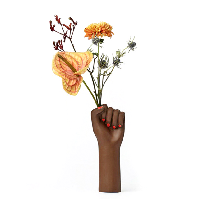 ceramic vase shaped as a fighting woman's hand, with painted red nails. A symbol of resilience, bravery, and strength. 